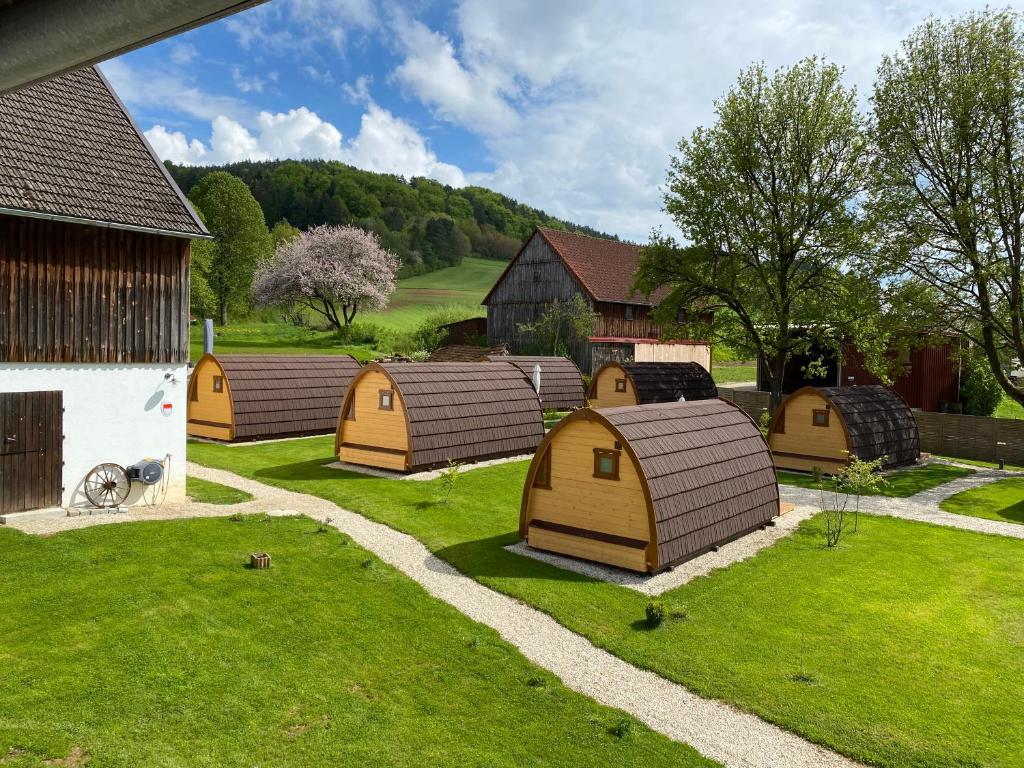 un grupo de pequeñas casas en un campo de hierba en Hüttendorf Fränkische Schweiz en Pottenstein