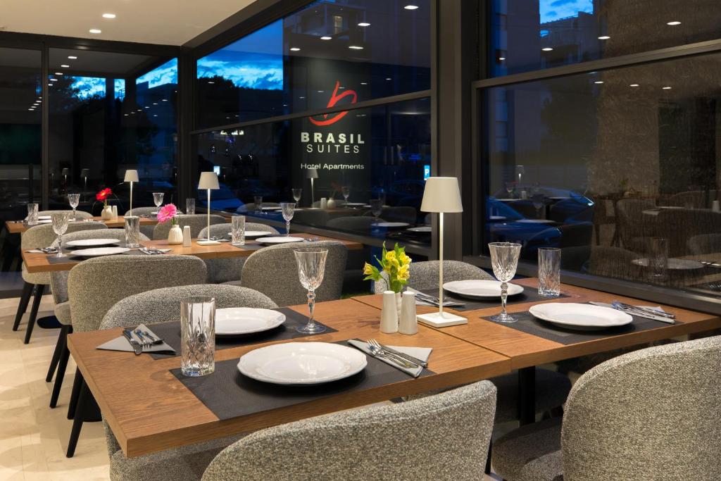 a dining room with tables and chairs and a restaurant at Brasil Suites Boutique Hotel in Athens