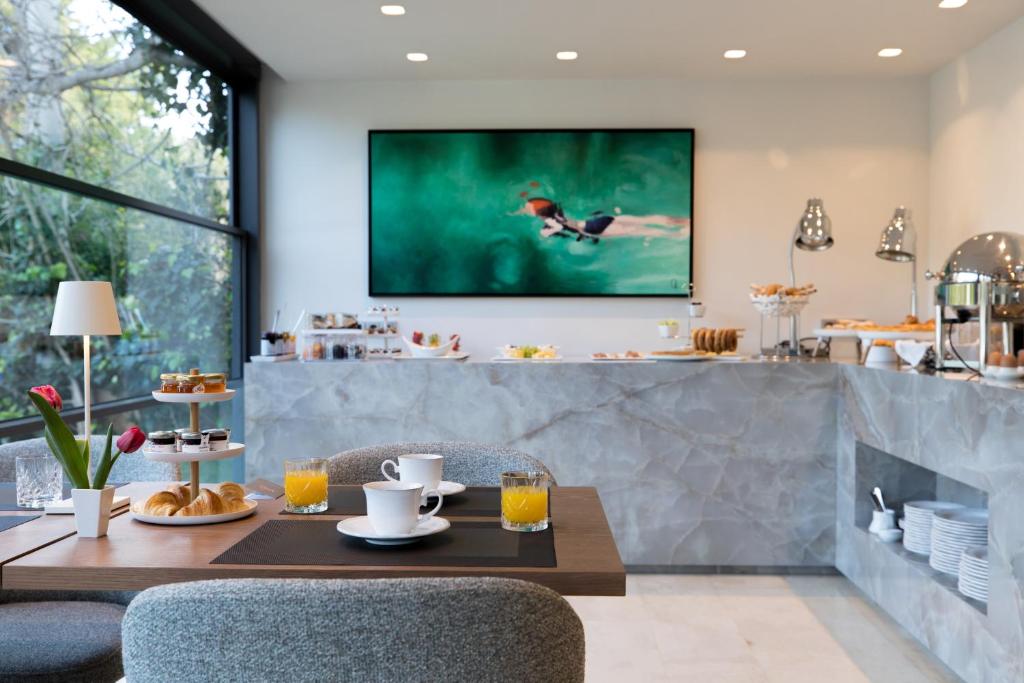 a kitchen with a table and a tv on the wall at Brasil Suites Boutique Hotel in Athens