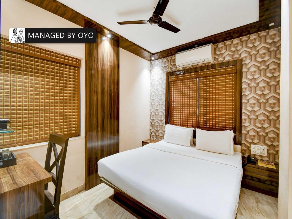 a bedroom with a bed and a desk and a window at Townhouse Ballygunge Near Quest Mall in Ballygunge