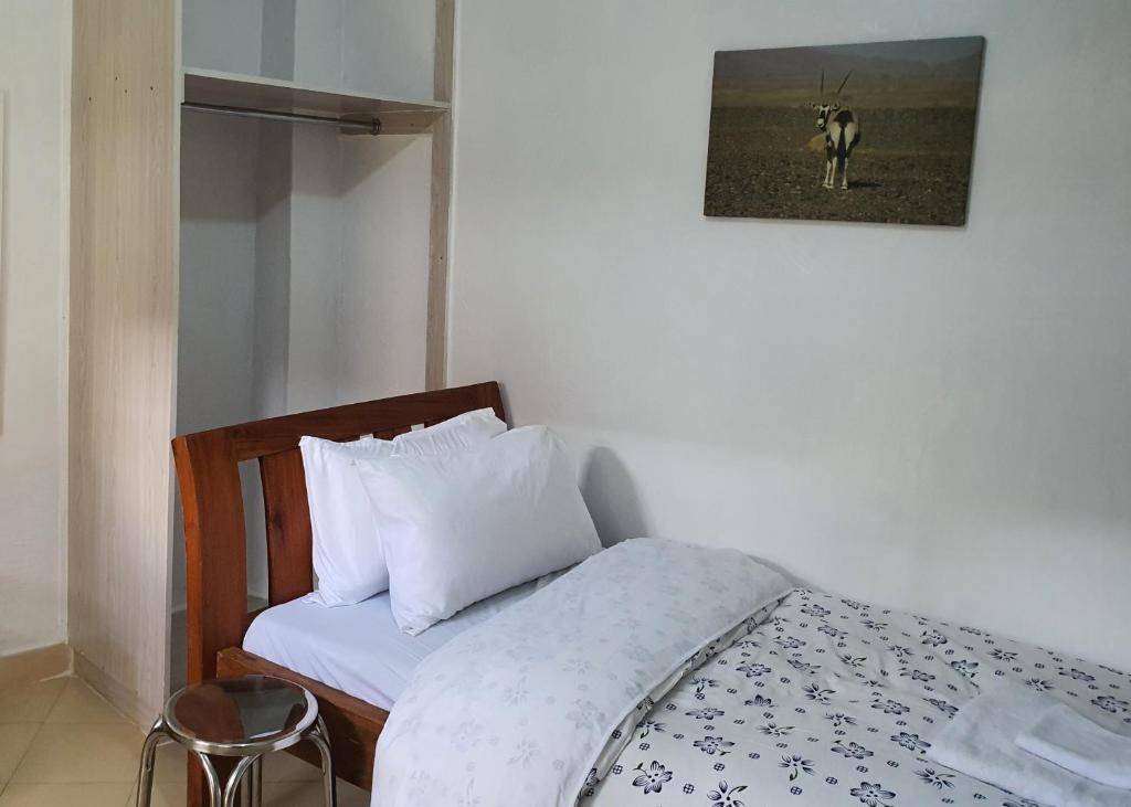 ein Schlafzimmer mit einem Bett und einem Bild einer Kuh in der Unterkunft Fahari1 in Meru