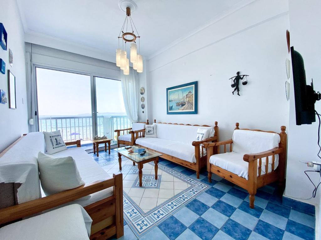 a living room with white furniture and a large window at Korali SeaView Apartment, Perea in Perea