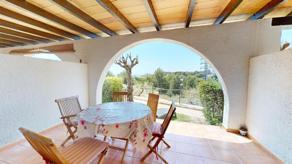 a dining room with a table and chairs on a balcony at Citronella in L'Ampolla
