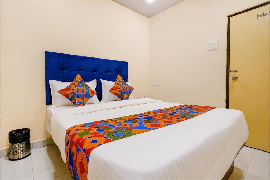um quarto com uma cama grande e uma cabeceira azul em FabExpress Kurla Inn em Mumbai