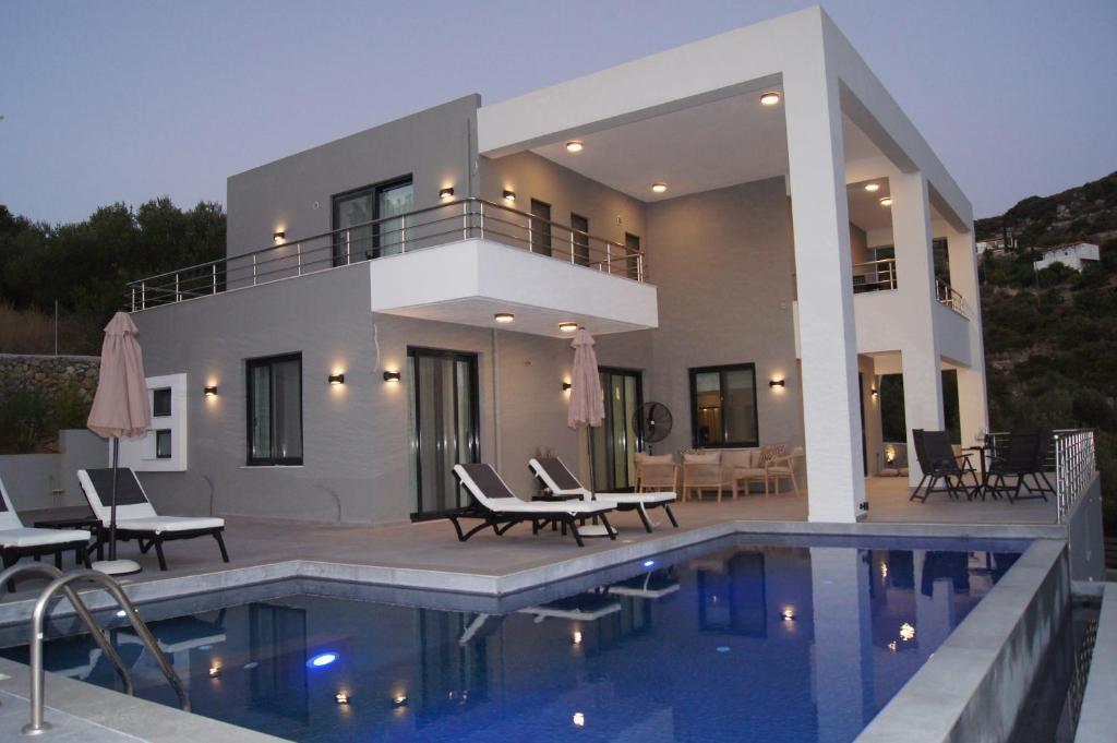 a house with a swimming pool in front of it at Bovilla Zoi in Almirida