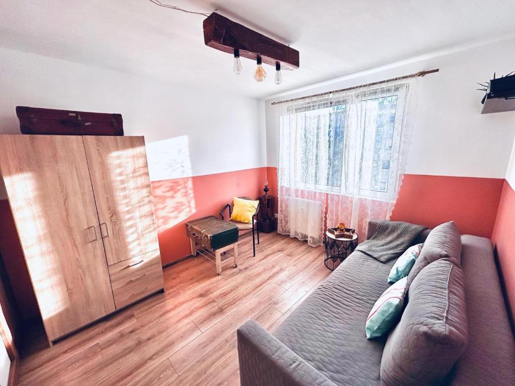 a living room with a couch and a large window at Apartament w sercu Karkonoszy in Jelenia Góra