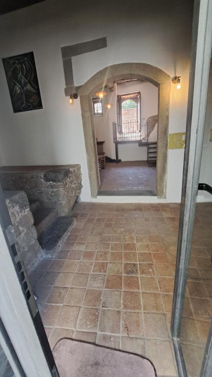 pasillo de una casa con suelo de baldosa y escalera en B&B Le Vie del Borgo en Castiglione di Sicilia