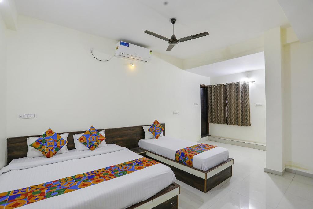 una camera con 2 letti e un ventilatore a soffitto di FabExpress Park View a Rāipur