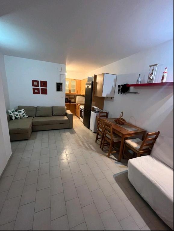 a living room with a couch and a table at Glifa Beach House Maisonette in Glida