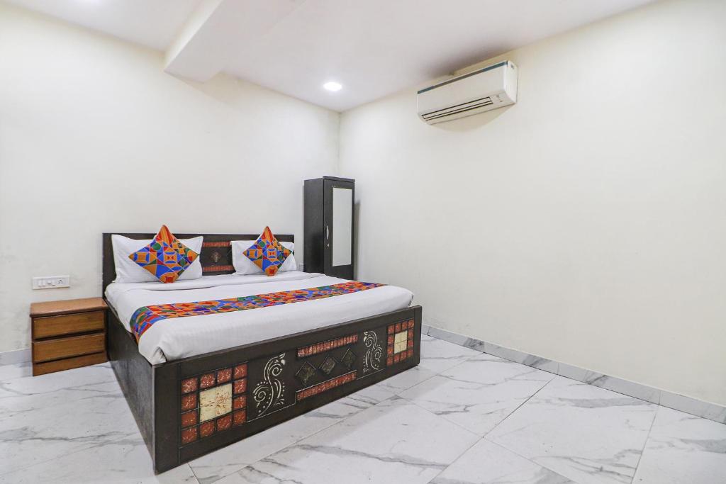 ein Schlafzimmer mit einem Bett in der Ecke eines Zimmers in der Unterkunft FabExpress King Stay in Neu-Delhi