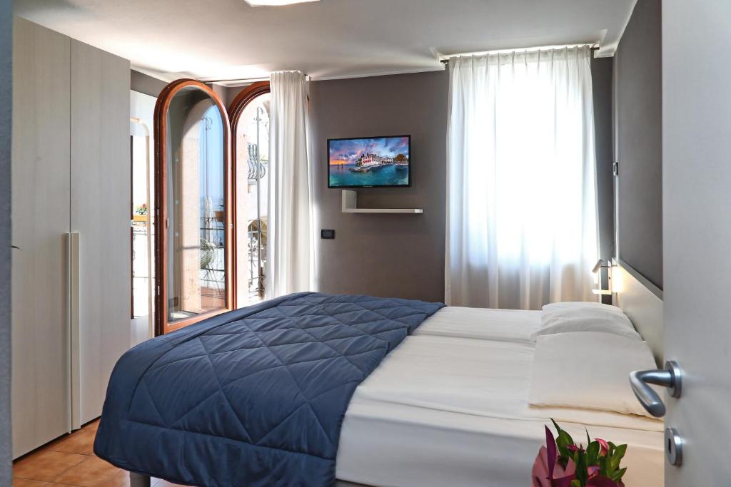 Un dormitorio con una cama grande y una ventana en Albergo All'Ancora, en Garda