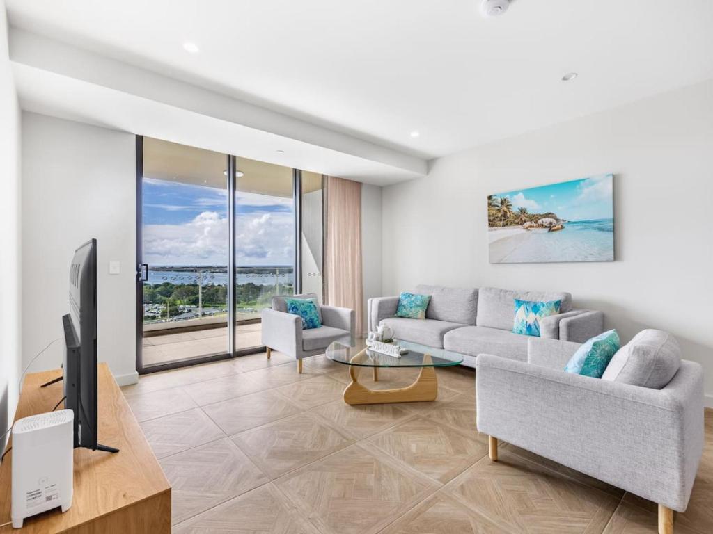 sala de estar con sofá y TV en Sweeping Ocean view Apt w Carpark and rooftop pool, en Gold Coast