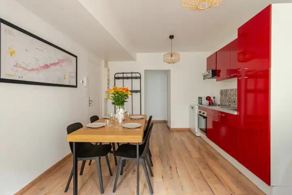 a dining room with a wooden table and red cabinets at L'escale des vignobles in Gevrey-Chambertin