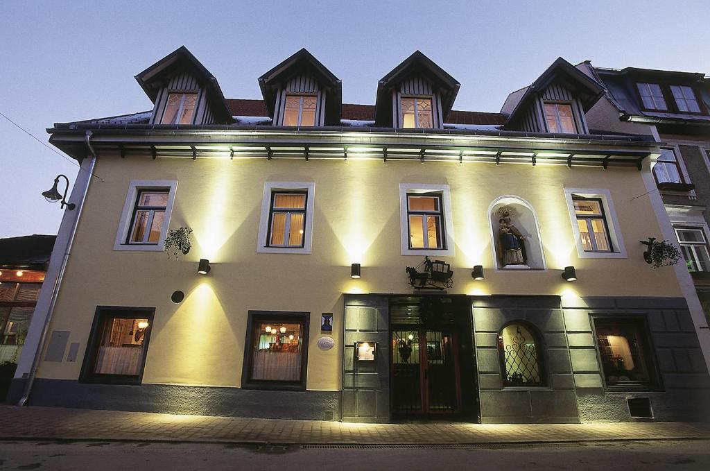 a large white house with lights on at Hotel Post Karlon in Aflenz Kurort