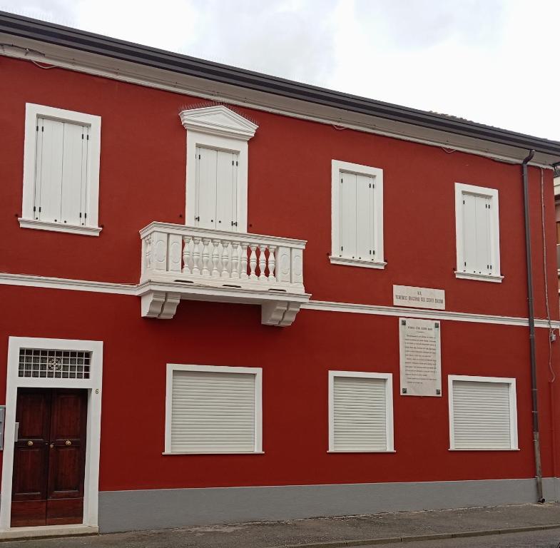 czerwony budynek z białym balkonem w obiekcie Palazzo Nicole w Adrii