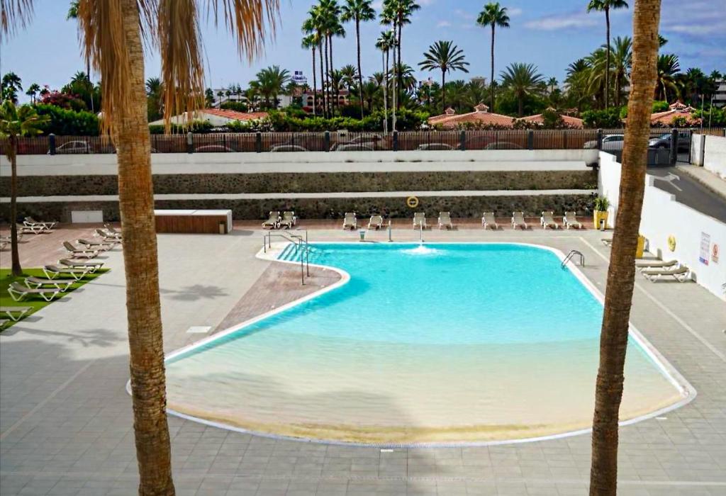 ein großer Pool mit Palmen in einem Resort in der Unterkunft Casa RAFFAELLA - Habitat - Near YUMBO in Maspalomas