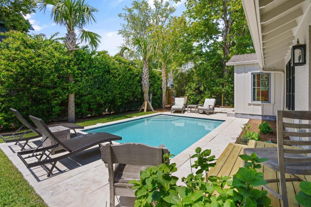 una piscina con sedie a sdraio e una casa di Park Cottage - 609 Oak Street a Demere Park