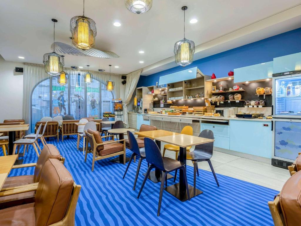 een restaurant met tafels en stoelen en een keuken bij ibis Styles La Rochelle Centre in La Rochelle