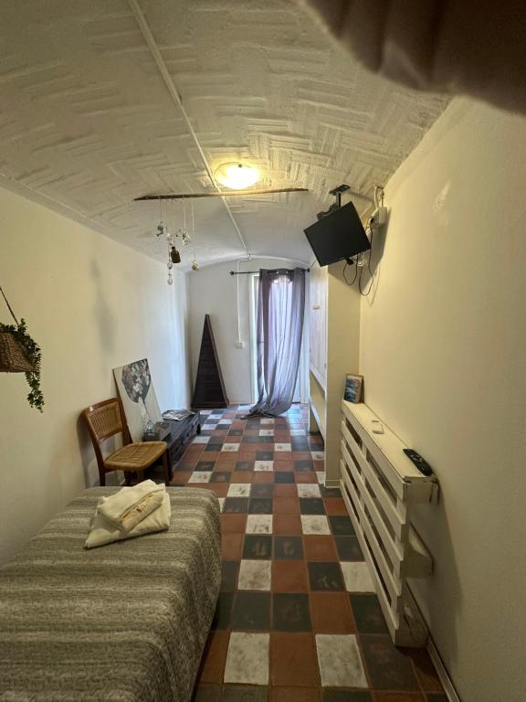Zimmer mit einem Bett und einem Schachbrettboden in der Unterkunft K.singleroom in San Giorgio