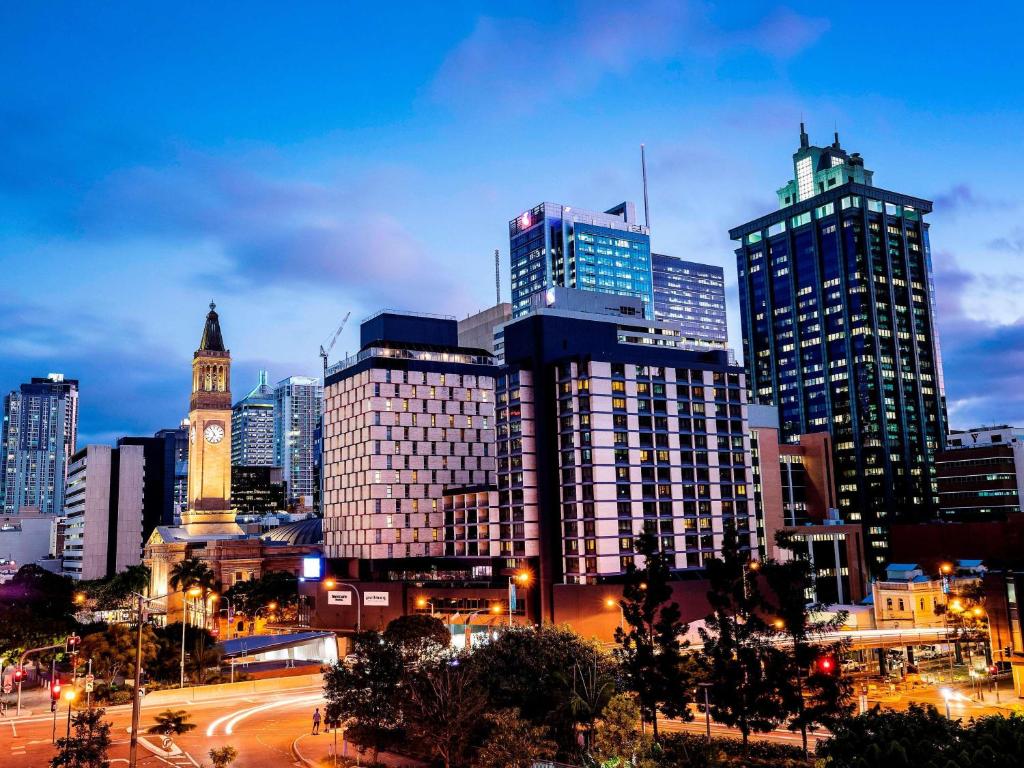 a city skyline at night with a clock tower at Pullman Brisbane King George Square in Brisbane