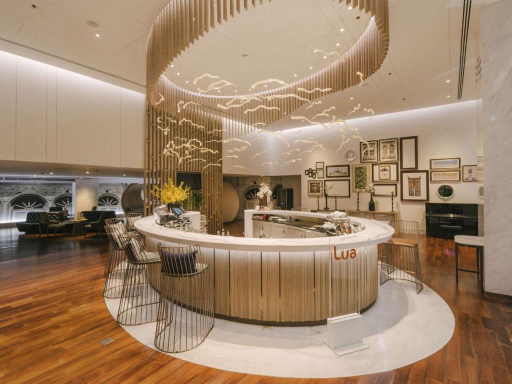 a lobby with a round reception desk in a building at Novotel Phuket City Phokeethra in Phuket Town