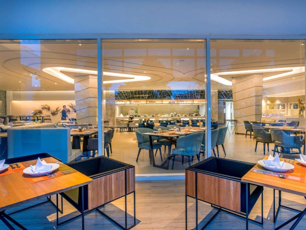 a restaurant on a cruise ship with tables and chairs at Novotel Phuket City Phokeethra in Phuket Town