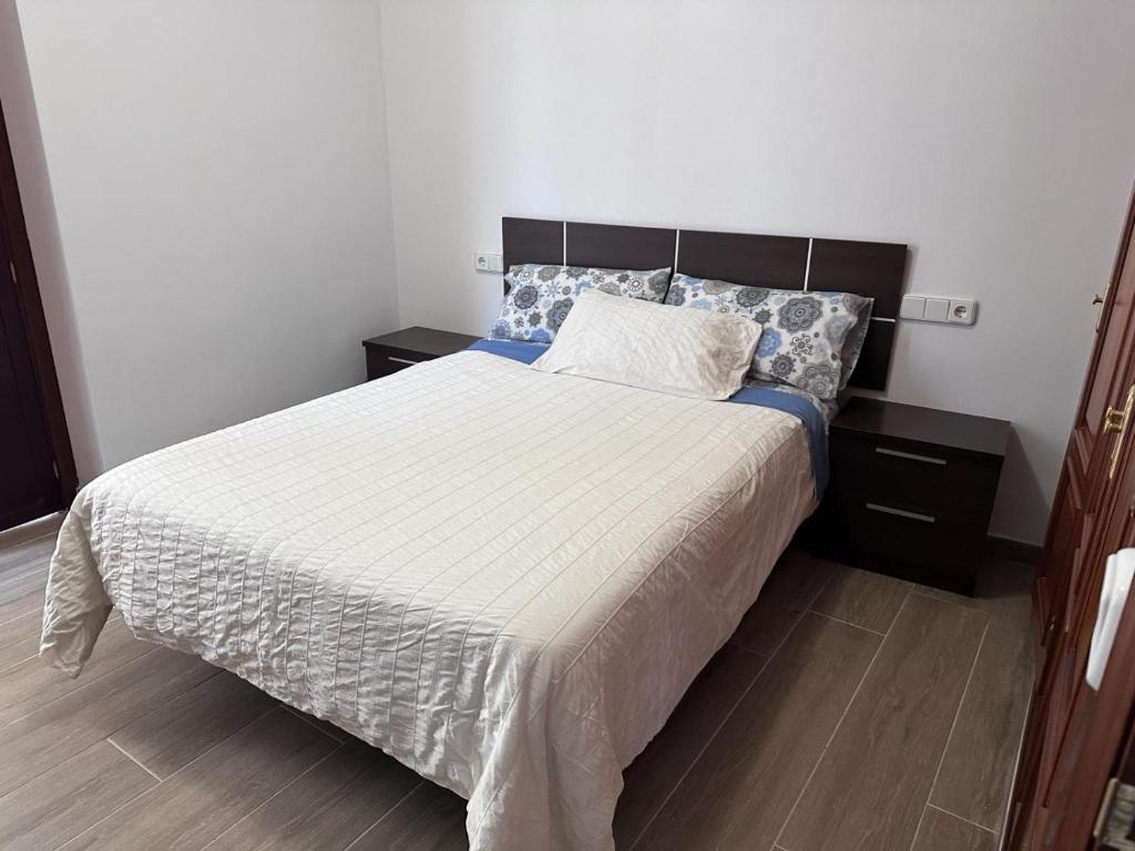 1 dormitorio con 1 cama grande y 2 mesitas de noche en Atico padre Aldama, en Sanlúcar de Barrameda