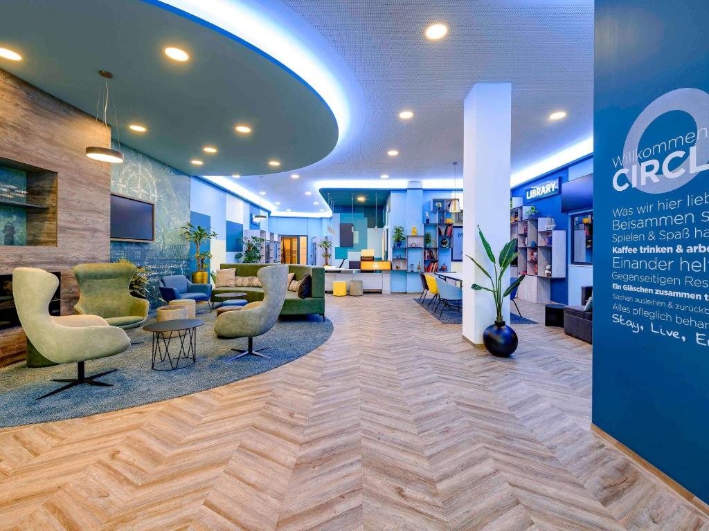 un vestíbulo de un hospital con sillas y mesas en Aparthotel Adagio Access Kiel en Kiel
