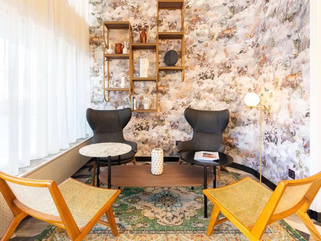 2 sillas y una mesa en una habitación con pared en Le Splendid Hotel Lac D'Annecy - Handwritten Collection, en Annecy