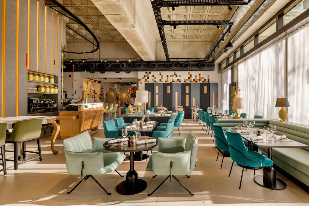 - un restaurant avec des tables et des chaises bleues dans une pièce dans l'établissement FirstName Bordeaux by Hyatt, à Bordeaux