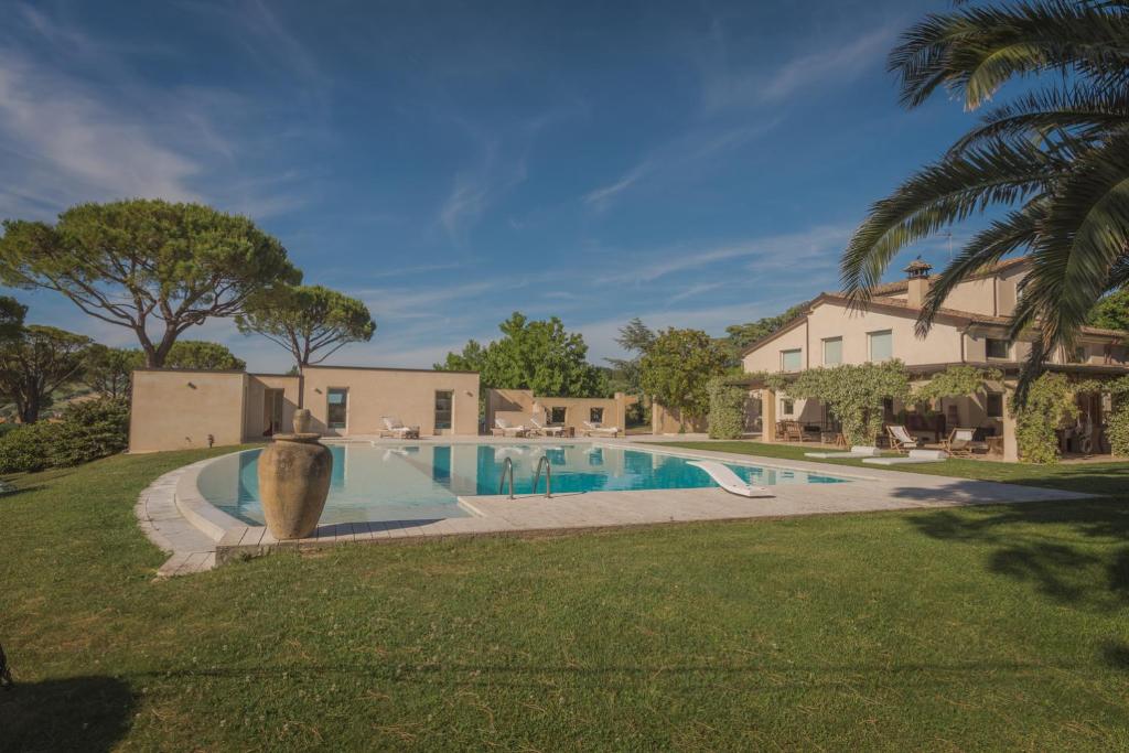 uma piscina num quintal ao lado de uma casa em VILLA DEI PINI - Camerano, villa con piscina em Camerano