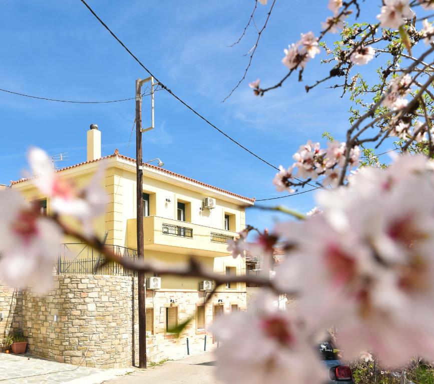 a building in the background with pink flowers in the foreground at Kentos Airy & Fully Equipped 3BR Family Maisonette in Chios