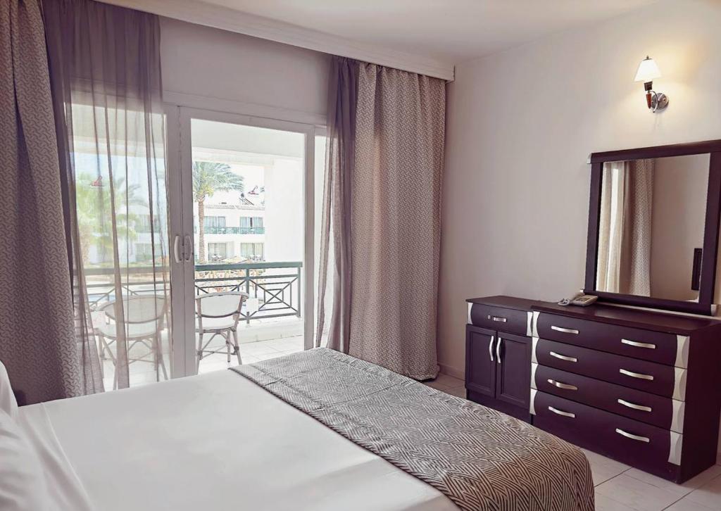 a bedroom with a bed and a mirror and a balcony at Panorama Naama Heights in Sharm El Sheikh