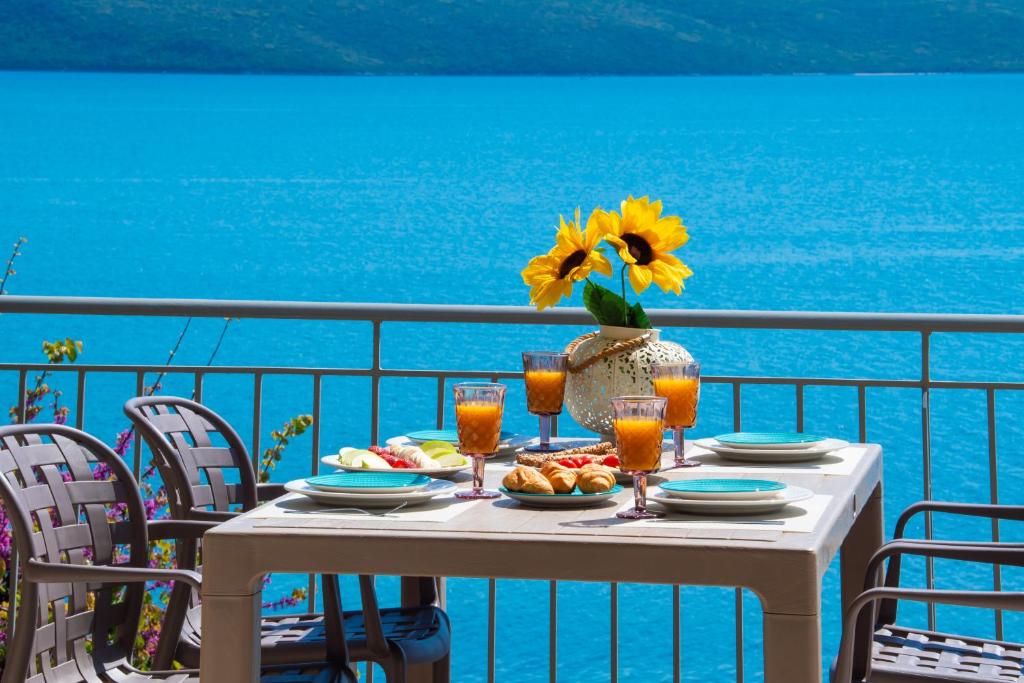 a table with a plate of food and a vase of flowers at Meteora Suites in Nikiana