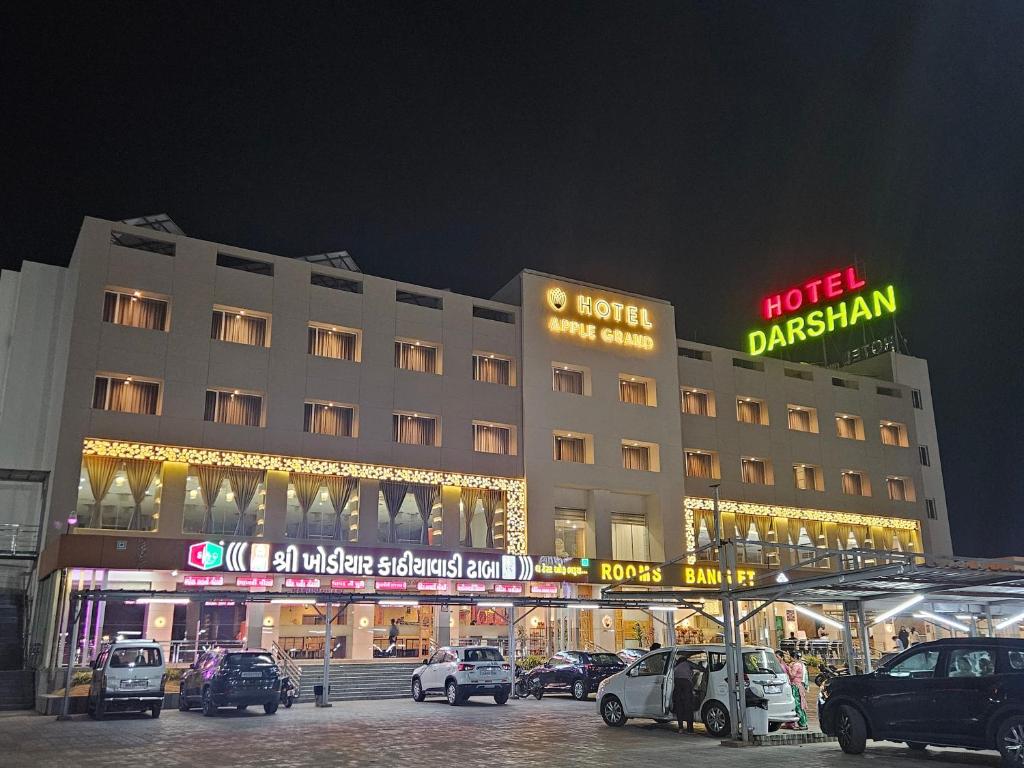 een gebouw waar 's nachts auto's voor geparkeerd staan bij Hotel Grand Darshan Vadodara in Vadodara