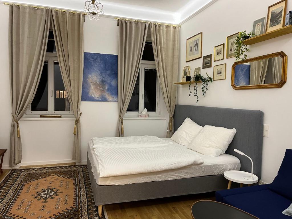 a small bedroom with a bed and two windows at Gemütliche Wohnung nur 15 Minuten ins Stadtzentrum in Vienna