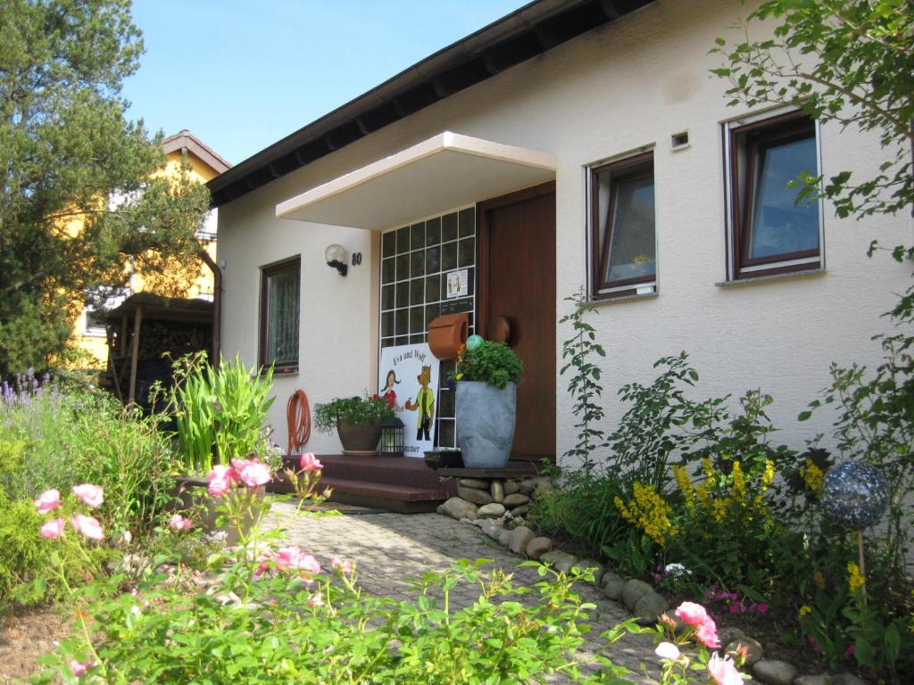ein Haus mit einem Blumengarten davor in der Unterkunft Eva Und Wolf Apartments in Sachsenheim