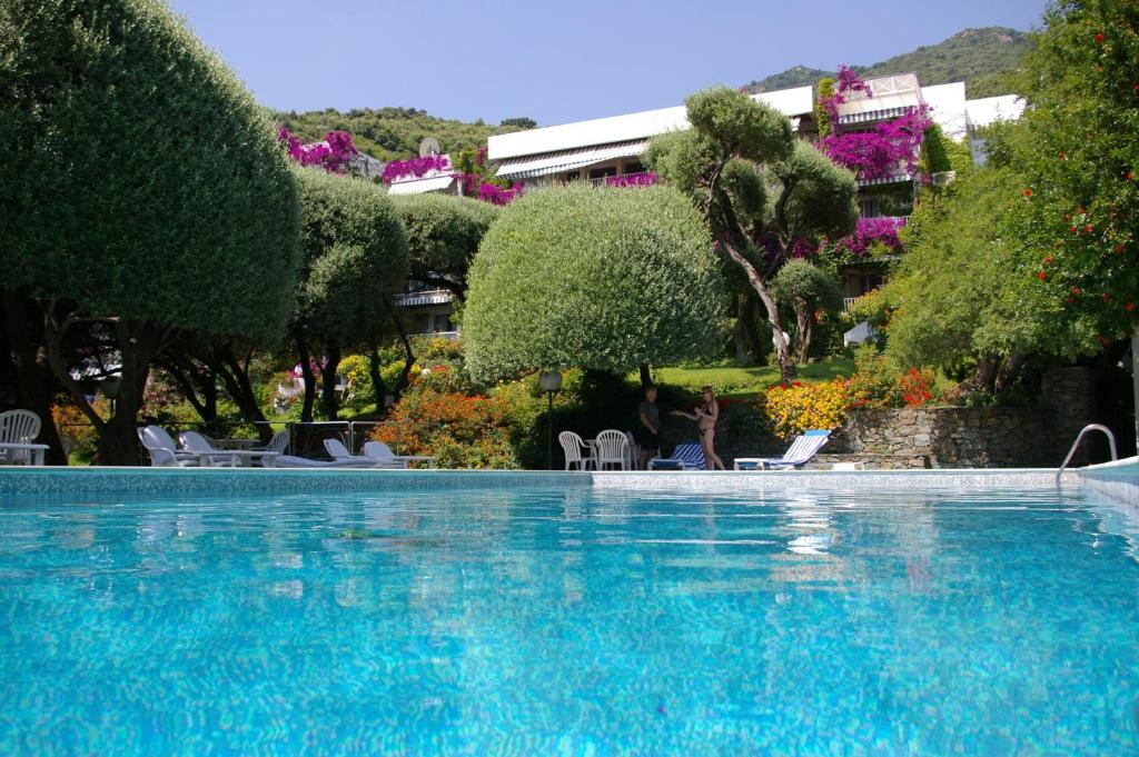 a large blue swimming pool with chairs and trees at Pietracap in Bastia
