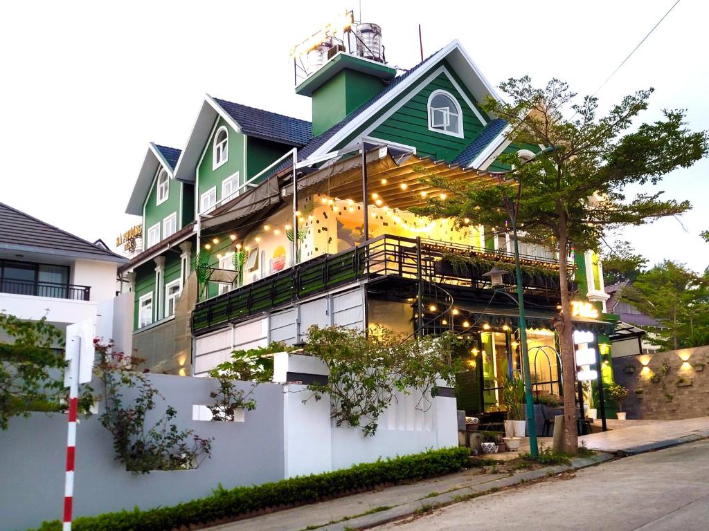 un bâtiment vert et blanc avec des lumières sur lui dans l'établissement Carnival Villa, à Đà Lạt