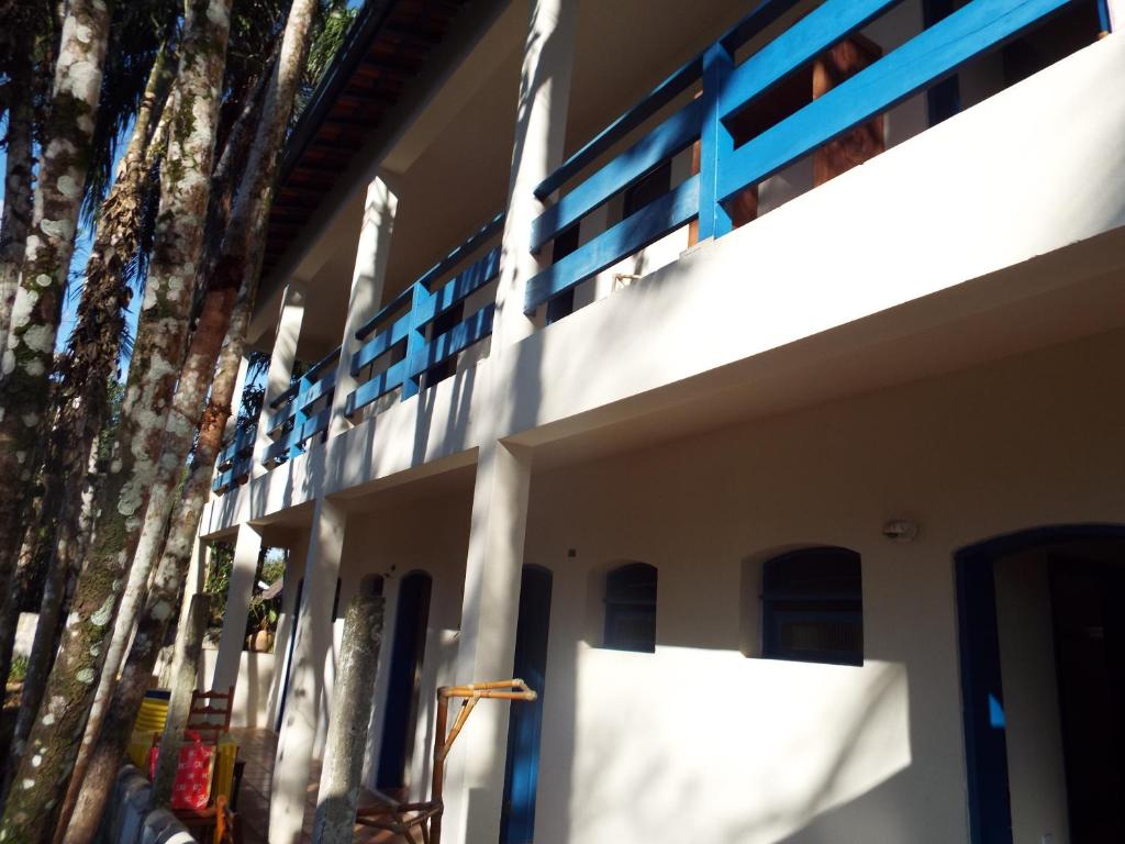 een zijdelings uitzicht op een gebouw met een blauwe leuning bij Pousada Canoeiro in Ubatuba