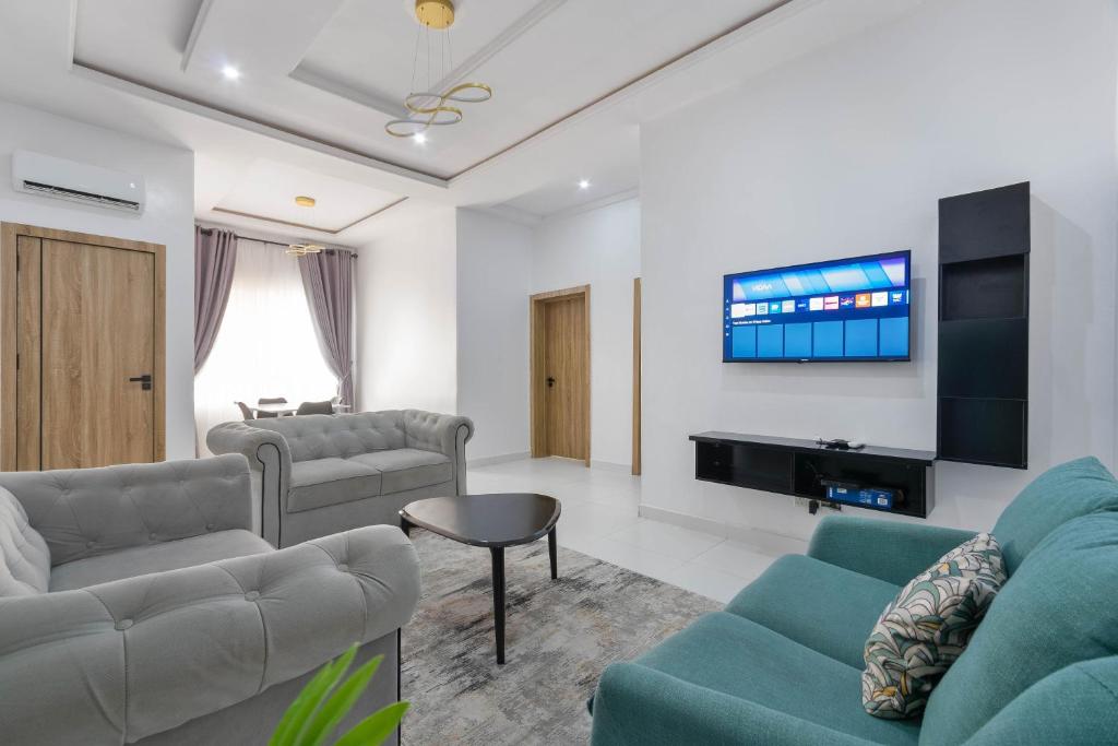 sala de estar con 2 sofás y TV de pantalla plana en Firenze Apartments Lekki en Lagos