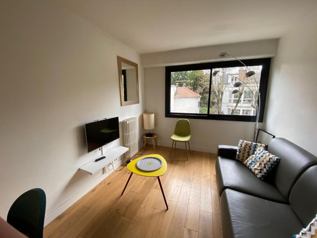 a living room with a couch and a table at Lovely Flat 4 peoples in Saint-Cloud