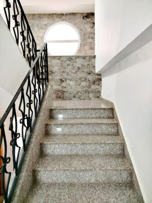 a staircase with a stone wall and a window at Résidence Inaya 2 SANS GARAGE Accès réservé aux voyageurs déclarés Uniquement PAS DE VISITEURS in Oran