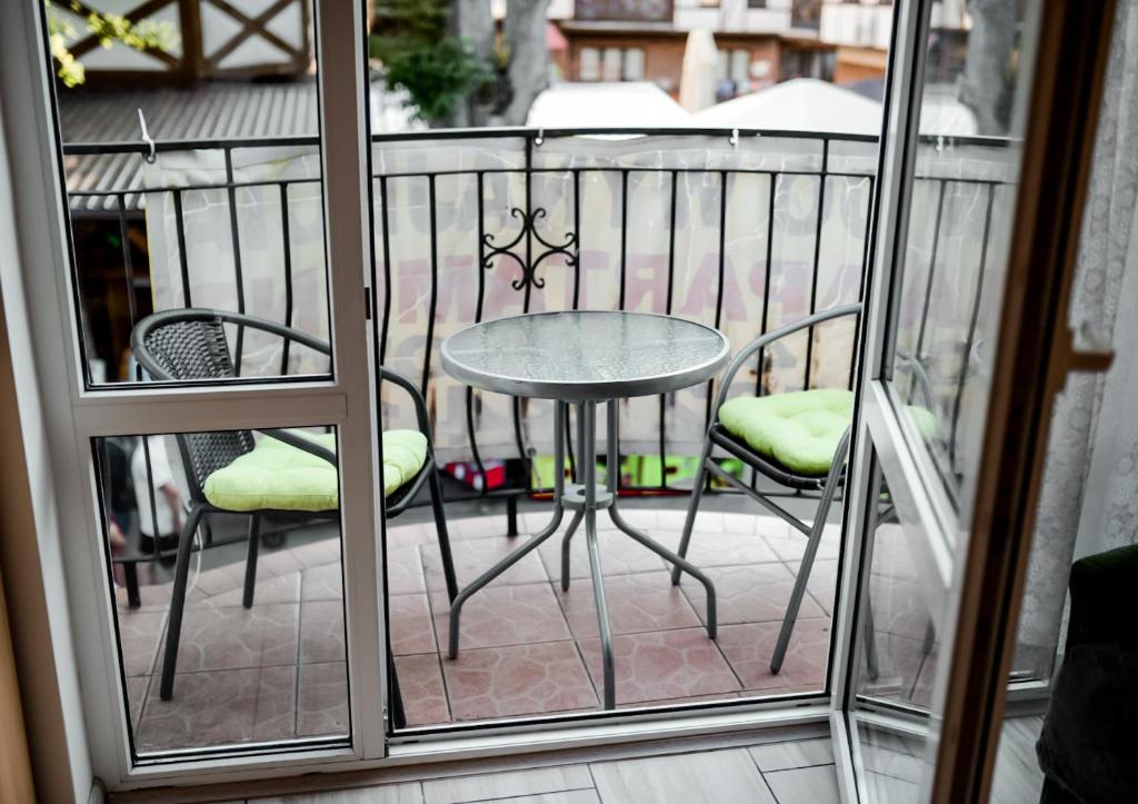 a small table and chairs on a balcony at Apartament EmKa z balkonem Rowy in Rowy