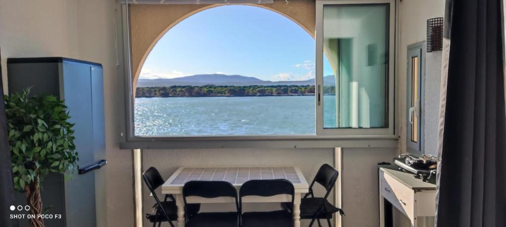 une pièce avec une table, des chaises et une fenêtre dans l'établissement Appartement T2 avec vue - Port Leucate - 4 personnes, à Leucate
