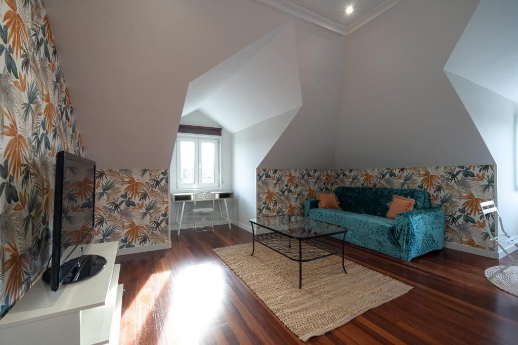 een woonkamer met een blauwe bank en een tafel bij Coqueto apartamento ideal para parejas in Muriedas