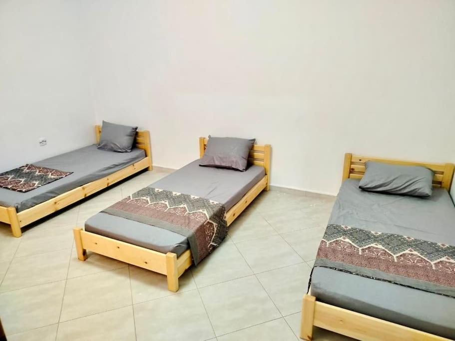 3 lits sont installés dans une pièce dans l'établissement Résidence Inaya, à Oran