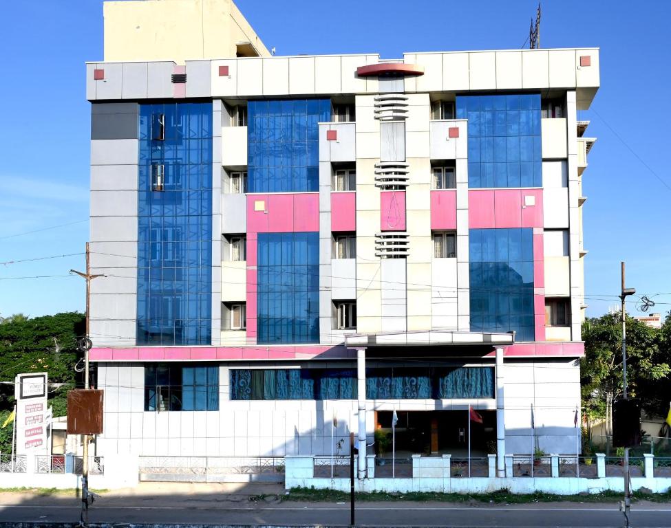 a tall building with pink and blue at SET Residency in Kumbakonam