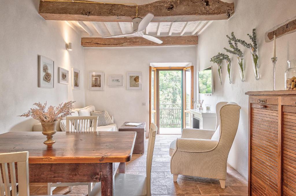 eine Küche und ein Esszimmer mit einem Holztisch und Stühlen in der Unterkunft Appartamenti Anguria Toscana in Sinalunga