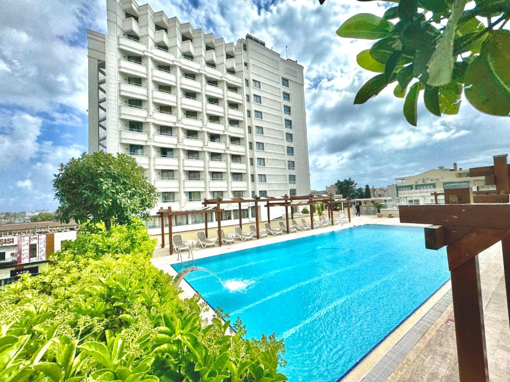 un gran hotel con piscina frente a un edificio en Best Western Plus Khan Hotel, en Antalya